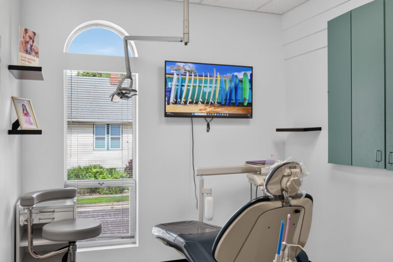 Modern dental treatment room with patient chair and digital monitor at Pacific Dental Center